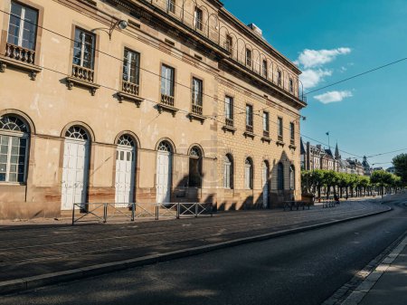 Téléchargez les photos : Un grand bâtiment historique avec des fenêtres barricadées le long d'une rue déserte à Strasbourg, France - en image libre de droit