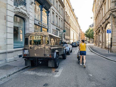 Photo for Strasbourg, France - Jul 2, 2023: Classic Land Rover Defender parked on a European urban street with historical buildings in the background. - Royalty Free Image