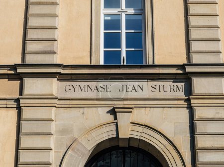 Téléchargez les photos : Gros plan sur l'inscription Gymnase Jean Sturm sur une façade de bâtiment classique. - en image libre de droit