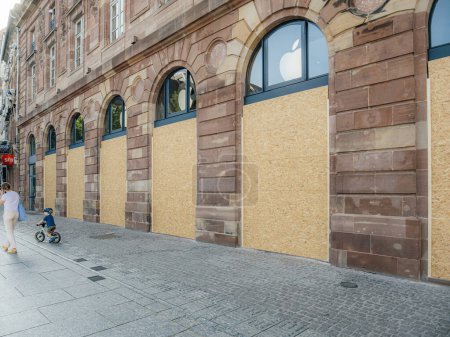 Foto de Estrasburgo, Francia - 2 de julio de 2023: Una tienda cerrada temporalmente con el logotipo visible de Apple a través de las ventanas superiores de una calle de la ciudad. - Imagen libre de derechos