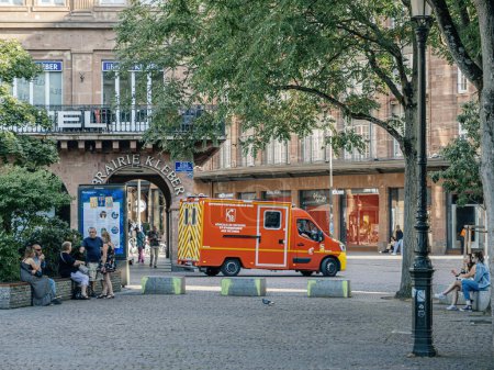 Photo for Strasbourg, France - Jul 2, 2023: An emergency vehicle and people relaxing in a city square with surrounding architecture - Strasbourg Alsce France - Royalty Free Image