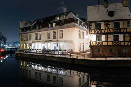 Foto de Hotel y restaurante junto al canal, iluminado por la noche con un reflejo en la superficie de las aguas - Imagen libre de derechos