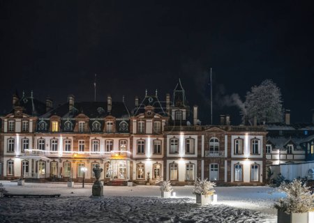 Téléchargez les photos : Terrain enneigé d'un majestueux bâtiment historique illuminé par un ciel nocturne dégagé - en image libre de droit