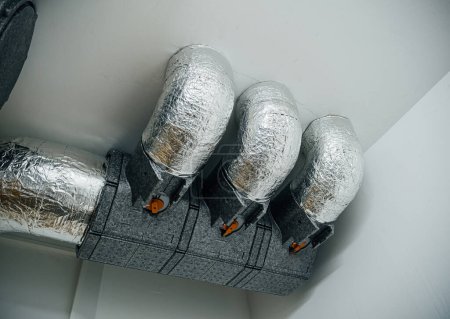 Isolierte Lüftungsrohre mit deutschem Etikett an der Decke eines modernen Gebäudes installiert - perfekte Frischluft im Haus