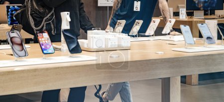 Photo for Paris, France - Sep 22, 2023: A wide image captures the bustling scene inside an Apple Store during the launch of the latest flagship smartphone, with unrecognizable people in the frame, as a relaxed - Royalty Free Image