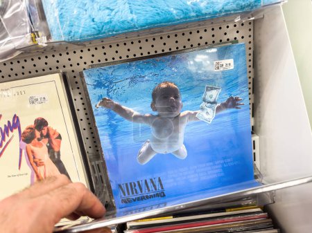 Photo for Berlin, Germany - Jan 18, 2024: Customer browsing music albums, iconic baby swimming for dollar album cover. - Royalty Free Image
