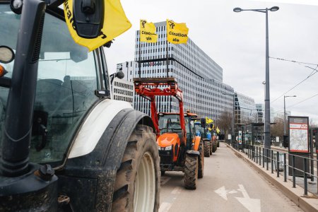 Foto de Estrasburgo, Francia - 6 de febrero de 2024: Gran grupo de tractores bloquea la calle en el distrito financiero y obstruye la entrada al Parlamento Europeo, como parte de una protesta contra las importaciones - Imagen libre de derechos