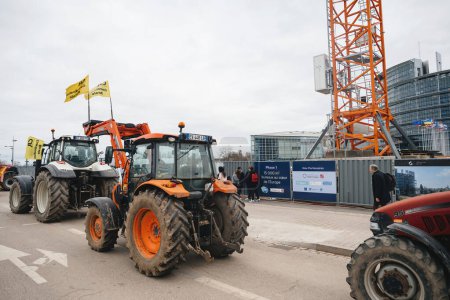 Foto de Estrasburgo, Francia - 6 de febrero de 2024: Una fila de tractores crea un bloqueo en la calle, obstruyendo la entrada al Parlamento Europeo, en protesta contra los alimentos importados con estándares más bajos y nuevos - Imagen libre de derechos