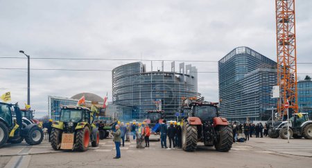 Foto de Estrasburgo, Francia - 6 de febrero de 2024: Manifestantes con tractores interrumpen la entrada del Parlamento Europeo por normas alimentarias más bajas y nuevos OMG en las importaciones. - Imagen libre de derechos