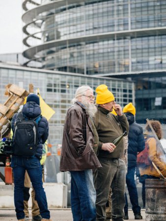 Foto de Estrasburgo, Francia - 6 de febrero de 2024: Los agricultores de edad avanzada con tractores bloquean el Parlamento Europeo, protestando contra las importaciones de baja calidad y los OMG. - Imagen libre de derechos