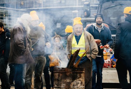 Foto de Estrasburgo, Francia - 6 de febrero de 2024: Escena intensa de humo y fuego en una protesta, donde los tractores bloquean al Parlamento Europeo contra los OMG y las importaciones de baja calidad. - Imagen libre de derechos