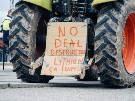 Photo for Strasbourg, France - Feb 6, 2024: Placard about lithium and agriculture on the back of a tractor as protesters block the entrance to the European Parliament, protesting against imported food with - Royalty Free Image