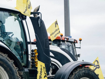 Téléchargez les photos : Strasbourg, France - 6 février 2024 : Vue en contre-plongée des tracteurs bloquant l'entrée au Parlement européen, en signe de protestation contre les importations de denrées alimentaires de moindre qualité et de nouveaux OGM - en image libre de droit