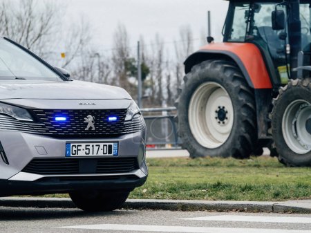 Téléchargez les photos : Strasbourg, France - 6 fév. 2024 : Une voiture de police avec une balise pendant que les manifestants bloquent l'entrée du Parlement européen, protestant contre les normes alimentaires importées et les nouveaux OGM - en image libre de droit