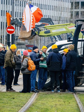 Téléchargez les photos : Strasbourg, France - 6 février 2024 : Une grande foule de manifestants avec des tracteurs bloquent la ligne de tramway et l'entrée au Parlement européen, protestant contre les normes alimentaires importées et les nouveaux OGM - en image libre de droit
