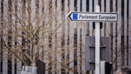 Téléchargez les photos : Panneau de direction pointant vers le Parlement européen, avec des immeubles de bureaux en arrière-plan - en image libre de droit