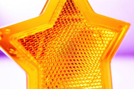 Foto de Superficie de protección reflectante: primer plano detallado de un objeto en forma de estrella de color amarillo brillante. - Imagen libre de derechos