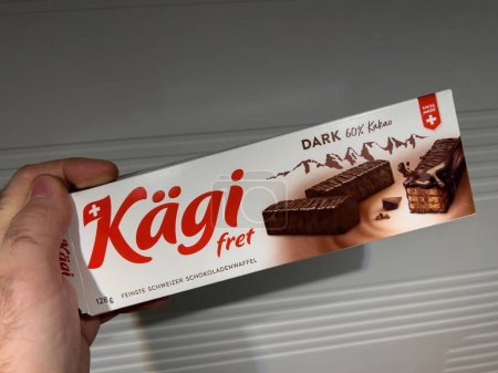 Photo for Paris, France - Feb 20, 2022: POV male hand holding package with Swiss Kagi Fret dark cacao biscuits waffles - Royalty Free Image