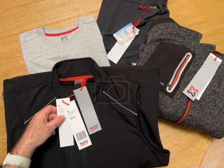 Photo for Lyon, France - Feb 27, 2022: POV male hand unboxing unpacking multiple clothes bought online from Wurth Modyf store for working professionals in renovations and industry - Royalty Free Image