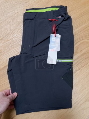 Photo for Lyon, France - Feb 27, 2022: POV male hand unboxing unpacking working shorts bought online from Wurth Modyf store for working professionals in renovations and industry - Royalty Free Image
