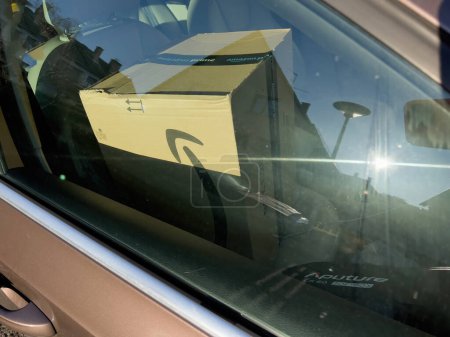 Photo for Paris, France - Feb 28, 2022: A view from the street captures a large Amazon Prime cardboard package with the logotype inside a parked car. - Royalty Free Image