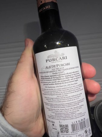 Foto de París, Francia - Mar 8, 2022: POV botella de mano masculina con vino blanco Purcari Alb de Purcari - Hecho en Moldavia - Imagen libre de derechos