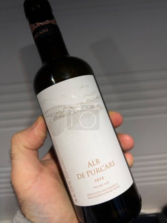 Foto de París, Francia - Mar 8, 2022: POV botella de mano masculina con Purcari Alb de Purcari vino blanco - Hecho en Moldavia - vino blanco seco - Imagen libre de derechos