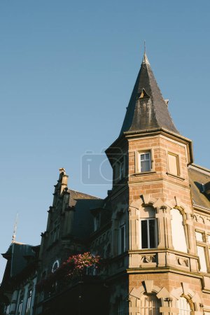 Tower of a historical building in Strasbourg, with clear blue sky in the background - luxury real estate