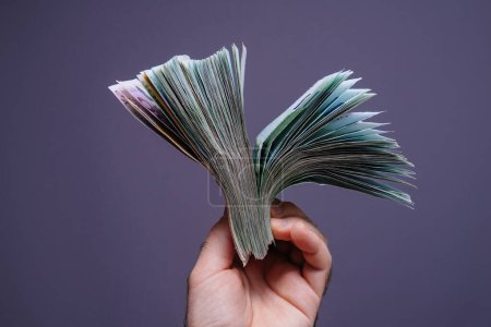 Foto de Una persona con confianza tiene una pila de dinero en sus manos. - Imagen libre de derechos