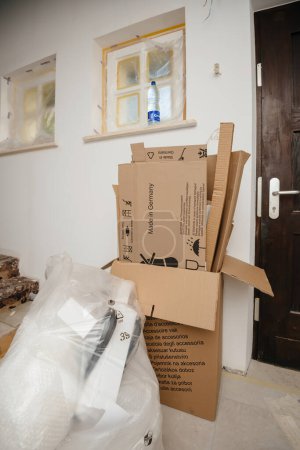 Foto de París, Francia - 8 de junio de 2020: Una habitación abarrotada durante el día en movimiento o la instalación de la cocina, con cajas de cartón abiertas y artículos envueltos en papel de burbuja - residuos de cartón para reciclar - Imagen libre de derechos