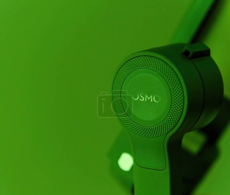 Photo for Paris, France - Aug 16, 2019: A detailed close-up of the Osmo logo prominently displayed on a phone stabilizer gimbal, set against a vibrant green background, showcasing the fusion of cutting-edge - Royalty Free Image