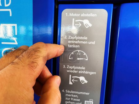 Foto de Berlín, Alemania - Jan 11, 2024: POV Siga estas instrucciones claras para llenar su automóvil con combustible en la bomba y luego pagar en el mostrador para una experiencia perfecta en la gasolinera. - Imagen libre de derechos