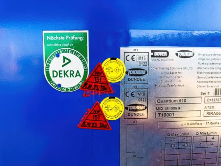 Photo for Berlin, Germany - Jan 11, 2024: Discover the certification process at the gas station featuring multiple stickers from authorities. Look for the Dekra stamp and Dover Touche Dundee - Royalty Free Image