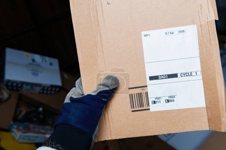 Photo for Bremen, Germany Dec 10, 2023: From a male hands perspective, holding an Amazon Prime cardboard package featuring labels from the Amazon Fulfillment Centers in POZ and Frankfurt, ensuring efficient - Royalty Free Image