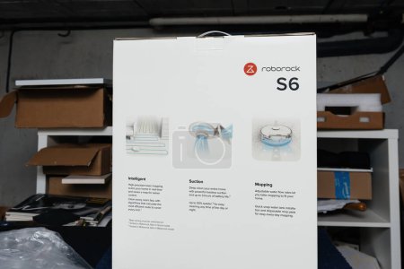 Téléchargez les photos : Brême, Allemagne - 10 déc. 2023 : Une boîte en carton présente le Roborock S6, l'aspirateur robotique automatique de renommée mondiale, avec ses fonctionnalités intelligentes expliquées, y compris la succion et - en image libre de droit