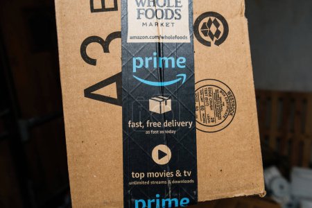 Photo for Bremen, Germany - Dec 10, 2023: A cardboard box with the Whole Foods Market logo signifies Amazon Primes fast, free delivery, possibly arriving as early as today - Royalty Free Image