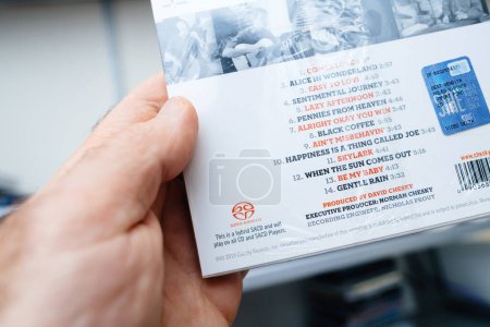 Photo for Paris, France - Dec 28, 2023: From a first-person perspective, a male hand holds the new Jazz SACD, a hybrid Super Audio Compact Disc, playable on all CD and SACD players. Produced by David Chesky, it - Royalty Free Image