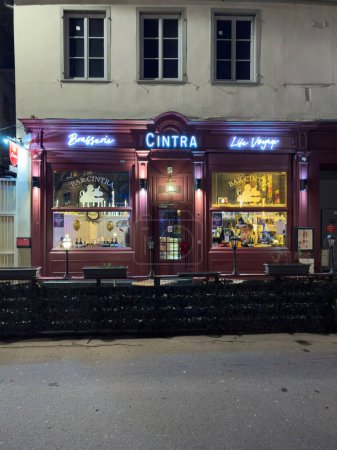 Téléchargez les photos : Strasbourg, France - 31 déc. 2023 : Une scène cosy se déroule au Cintra Brasserie Bar dans le centre de Strasbourg la nuit du Nouvel An, avec quelques personnes à l'intérieur, profitant de l'ambiance et des festivités de la - en image libre de droit