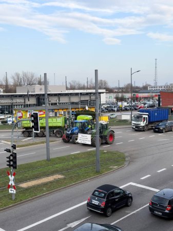 Téléchargez les photos : Kehl, Allemagne - 9 janv.2024 : Une perspective aérienne capture la scène de tracteurs coupant des routes dans une ville allemande dans le cadre d'une protestation contre les politiques agricoles plus vertes. - en image libre de droit