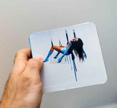 Photo for Paris, France - Jan 15, 2024: From a first-person perspective, a male hand delicately holds the latest Zazie Rodeo album against a clean white background, showcasing the beauty of audiophile music - Royalty Free Image