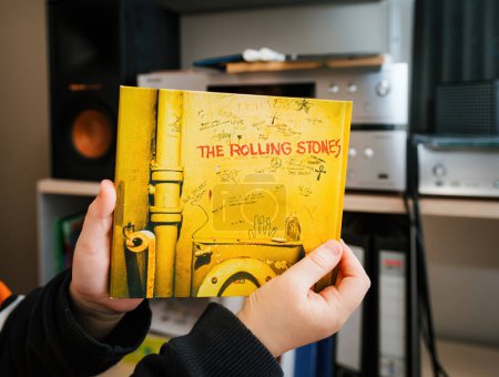 Foto de París, Francia - 17 de enero de 2024: En una toma POV, las manos de los niños pequeños sostienen delicadamente el icónico álbum de los Rolling Stones SACD Beggars Banquet, que muestra el patrimonio musical que trasciende a las generaciones. - Imagen libre de derechos