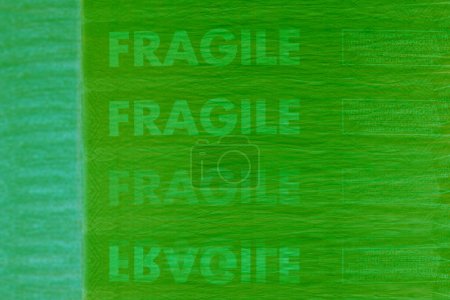 Foto de Vista detallada de un carrete de hilo verde, mostrando el color vibrante y la textura de cerca en un entorno metaverso digital con la palabra Frágil - Imagen libre de derechos