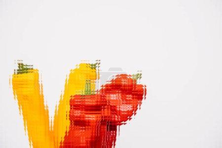 Téléchargez les photos : Dans la métaverse numérique, une main masculine berce délicatement un bouquet de poivrons mûrs, délicieux rouges et jaunes, symbolisant l'avenir de la nourriture durable et nutritive. - en image libre de droit