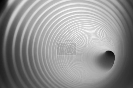 Perspective monochrome d'une caméra à l'intérieur d'un tunnel d'évacuation en plastique blanc, servant à l'évacuation de l'air et de l'eau en cas d'urgence.