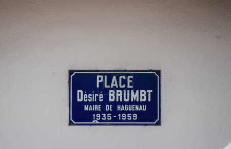 Ein blaues Straßenschild in Haguenau kennzeichnet den Place Desire Brumbt, der den Bürgermeister von Haguenau von 1935 bis 1959 inmitten des historischen Charmes der Stadt ehrt..