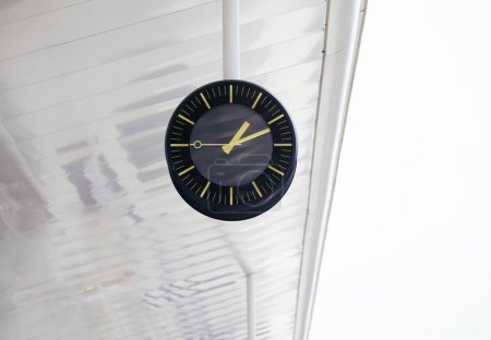 Téléchargez les photos : Une horloge est suspendue au plafond d'un bâtiment, retardant le temps au-dessus de la foule animée en dessous - gare - en image libre de droit