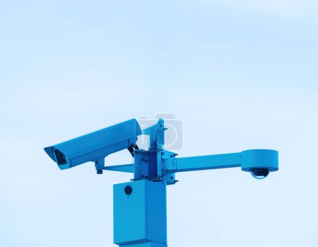 Foto de Una cámara de seguridad está conectada de forma segura a un poste de metal alto, monitoreando el área para fines de seguridad y vigilancia. - Imagen libre de derechos