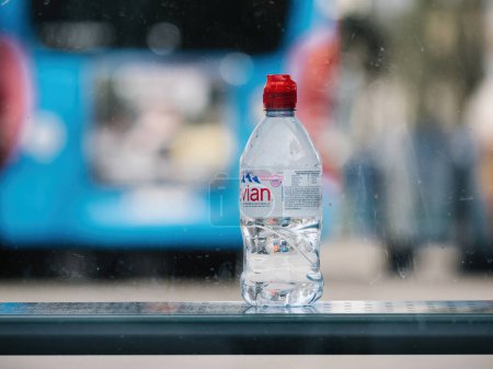 Foto de Haguenau, Francia - 20 de marzo de 2024: Una botella de agua Evain se coloca sobre una mesa de madera, con una composición simple y minimalista - Imagen libre de derechos