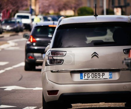 Téléchargez les photos : Silver Citroen voiture conduite sur une route de la ville à Haguenau, au milieu de la circulation et tous les jours de trajet urbain. - en image libre de droit