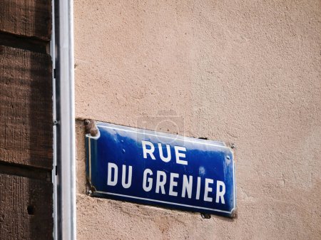 Téléchargez les photos : Panneau de rue bleu vintage est monté sur le côté d'un bâtiment, fournissant des conseils aux passants en naviguant dans les rues de la ville Rue du Grenier - en image libre de droit